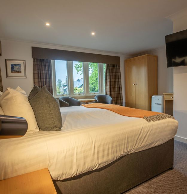 Room with a king-sized bed, wardrobe, window and TV
